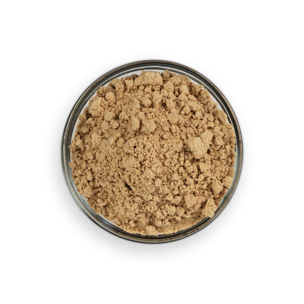Brown powder in a clear glass container on a white background
