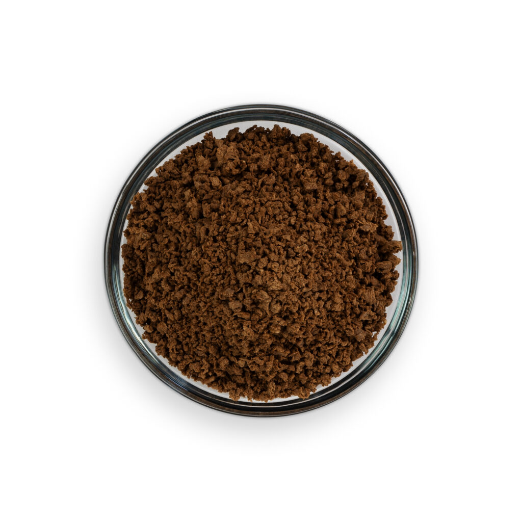 Glass container filled with brown ground substance on a white background