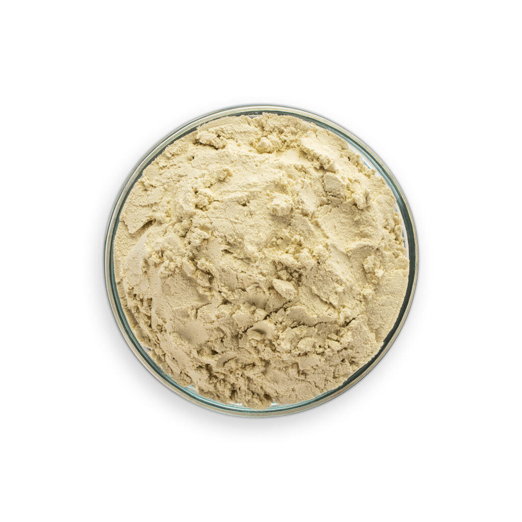 Beige powder in a glass bowl on a white background