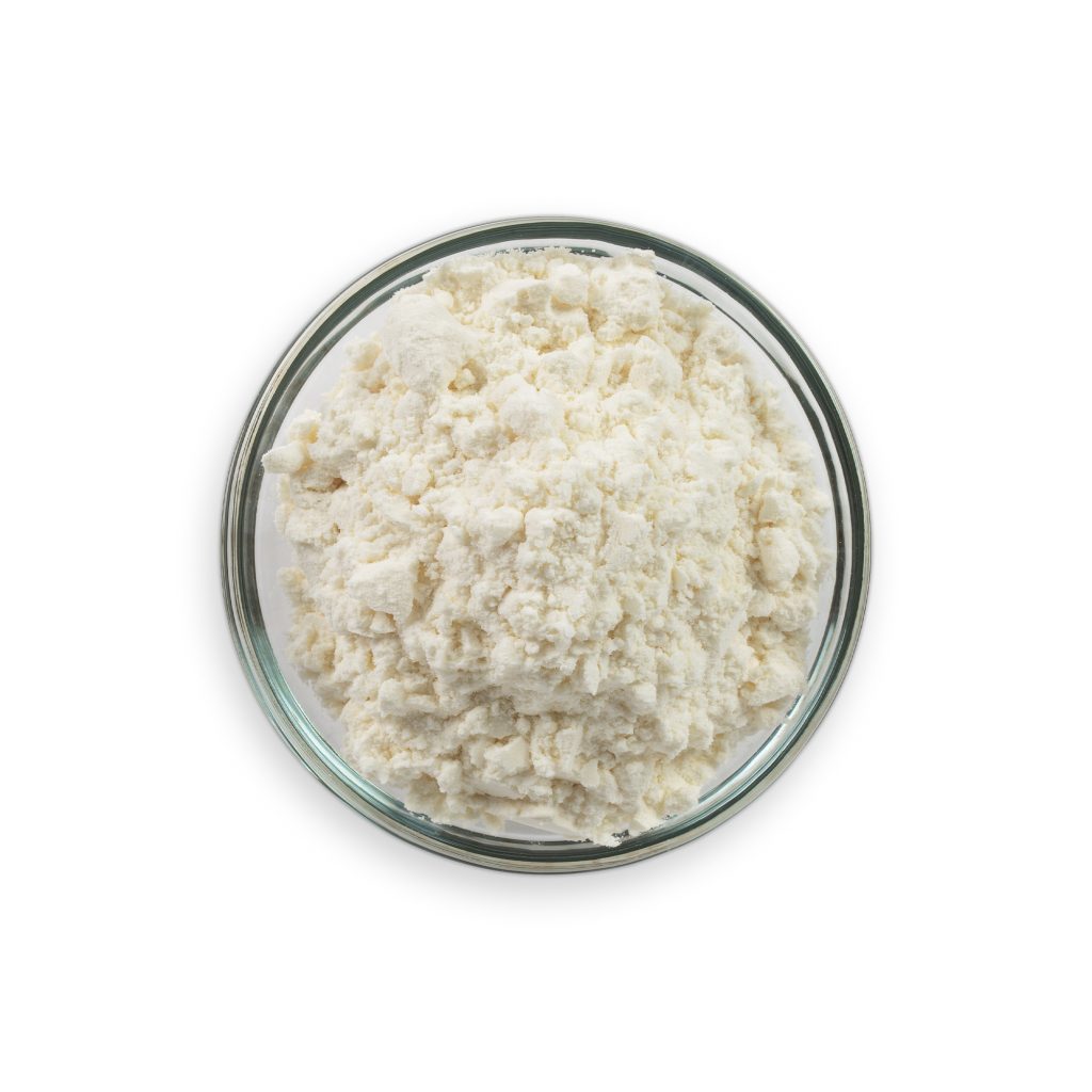 Glass bowl filled with white cottage cheese on a white background